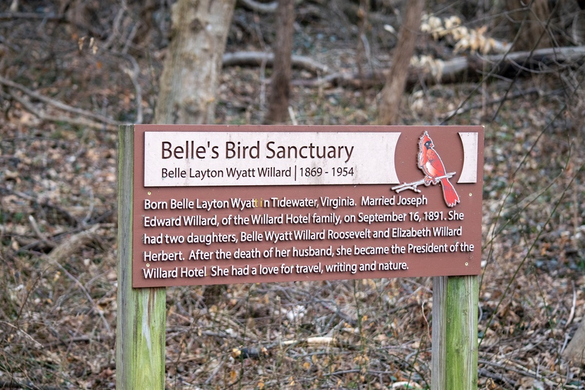 Belles_Bird_Sanctuary Park Trail Sign against wooded background