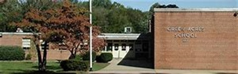 brick building with green acres sign