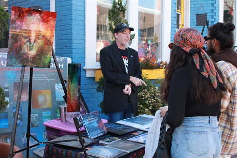 man in booth with art around him