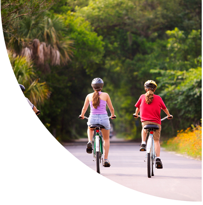 Children riding bicycles on a path surrounding by trees